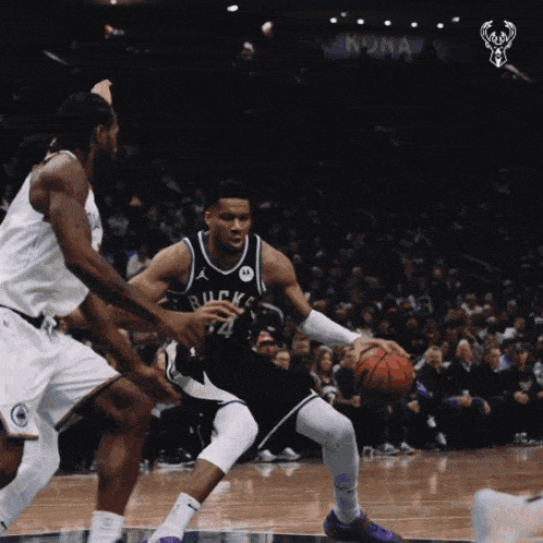 a basketball player with the number 24 on his jersey dribbles the ball