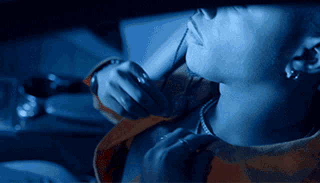 a close up of a person 's face with a blue light shining on it