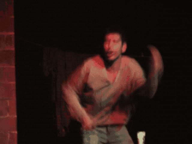 a blurry picture of a man in a sweater dancing in a dark room
