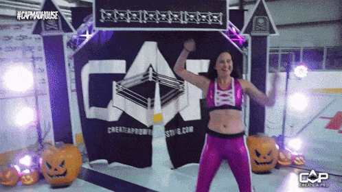 a woman in a pink outfit is standing in front of a sign that says cap madhouse