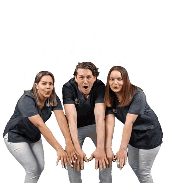 a man and two women are posing for a photo with their hands on their knees