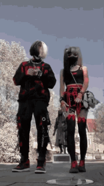 a man and a woman are standing next to each other with the man wearing a mask