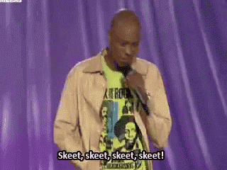 a man is standing on a stage holding a microphone and saying skeet skeet skeet skeet