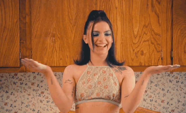 a woman throws flour in the air while wearing a crop top