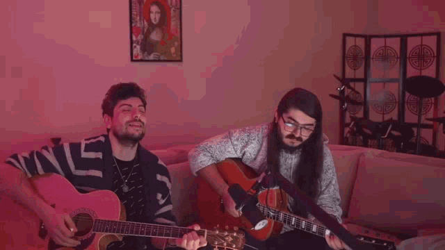 two men are playing guitars in front of a pink wall with a purple sticker that says ' jvinesinedalar '