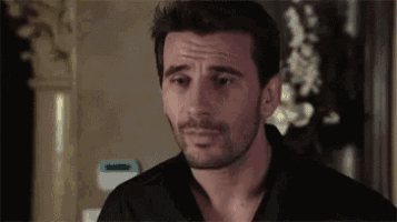 a man with a beard and a black shirt is looking at the camera .