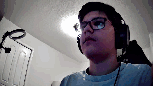 a man wearing glasses and headphones with a bee logo on his shirt