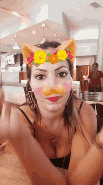a woman wearing a cat mask with a flower crown on her head
