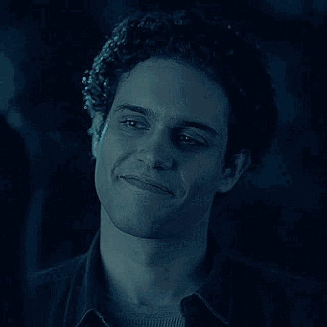 a close up of a man 's face in the dark with a smile on his face .