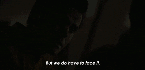 a man says " but we do have to face it " in a dark room