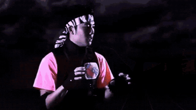 a person wearing a karate uniform is holding a pair of red boxing gloves