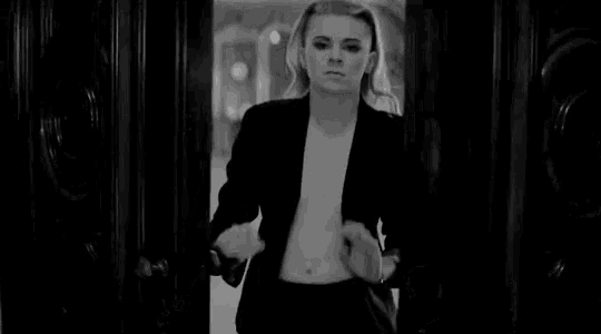 a black and white photo of a woman without a shirt in a doorway .
