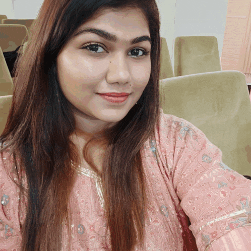 a woman in a pink shirt takes a selfie with her phone