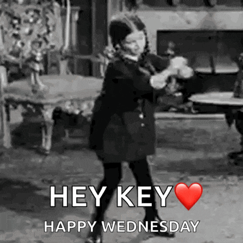 a black and white photo of a girl dancing with the words `` hey key happy wednesday '' written below her .
