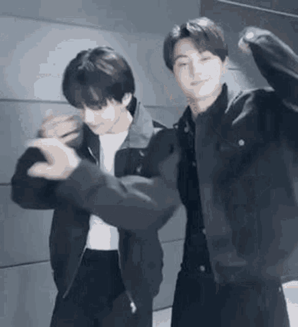 two men are standing next to each other in a room and dancing .