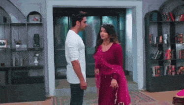 a man and a woman are standing next to each other in a room .