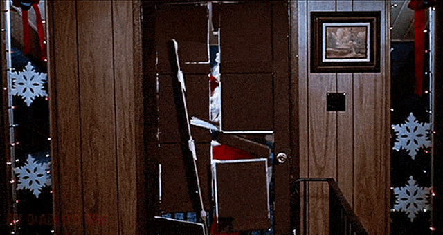 a broken door with a picture on the wall above it