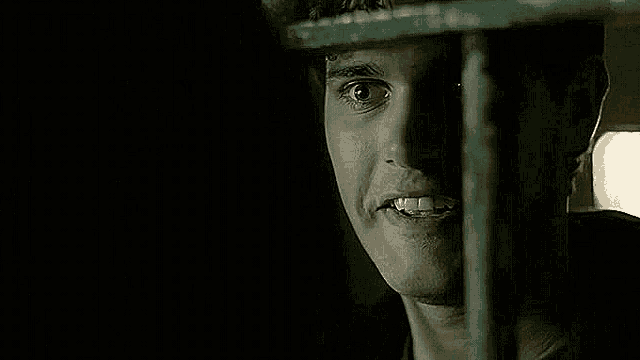 a close up of a man 's face behind a fence .