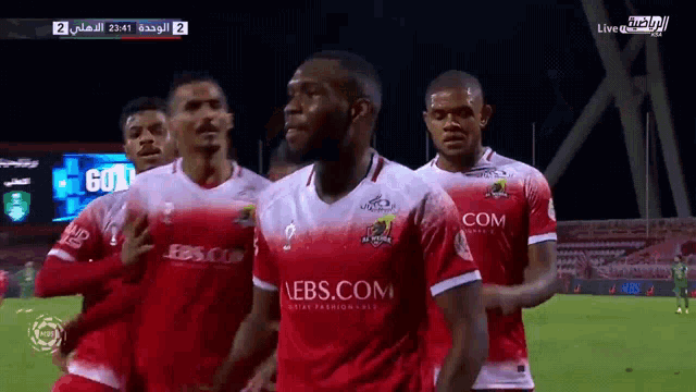 a group of soccer players wearing red jerseys with ebs.com written on the front