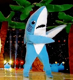 a person in a blue and white shark costume dancing