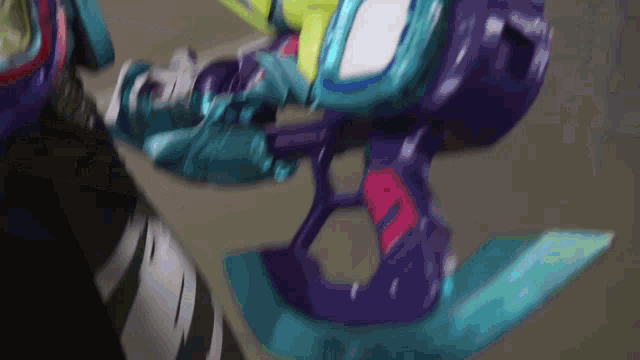 a close up of a purple and blue toy with the letter r on it