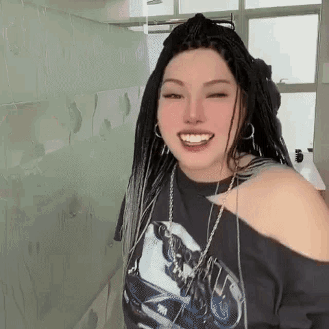 a woman with braids is wearing a black t-shirt with a picture of a car on it .