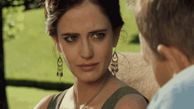 a woman wearing earrings with the letter o on them