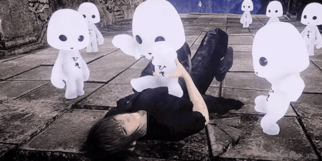 a man is laying on the floor surrounded by white stuffed ghosts