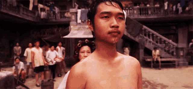 a shirtless man is standing in front of a crowd