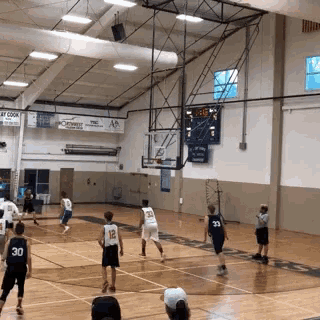 a basketball game is being played in a gym with a sign that says " play cook " on it