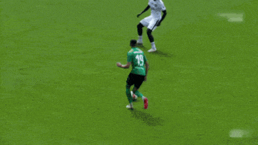 a soccer player kicks a ball in front of a sign that says bogdrako