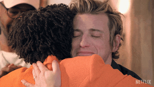 a man is hugging another man with a netflix logo in the corner