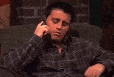 a man sitting in a chair talking on a cell phone