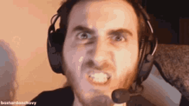 a man with a beard is wearing headphones and a microphone .