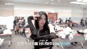 a woman in a black crop top is standing in a room with a sign that says signal