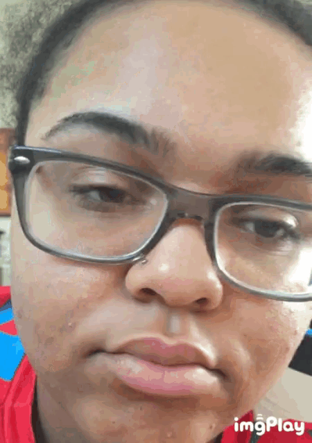 a close up of a woman 's face with glasses and the words imgplay visible