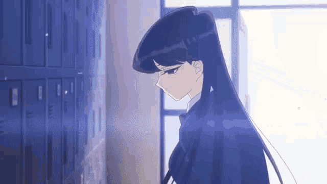 a girl with long black hair is standing next to a row of lockers in a room .