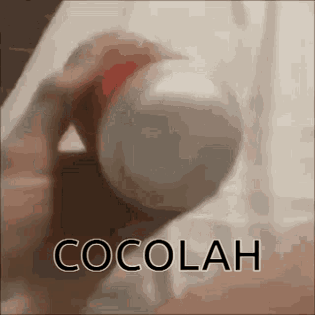 a person is holding a bottle of cocolah
