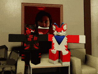 a person in a black and red outfit is standing next to a red and white stuffed animal in a living room
