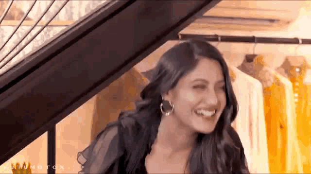 a woman in a black dress is laughing in a store .