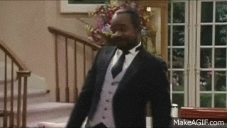 a man in a suit and tie is walking down stairs in a house .