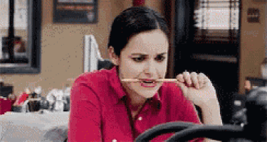 a woman is holding a pencil in her mouth .