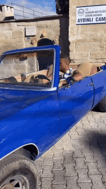 a blue car with a sign that says aydinli cami