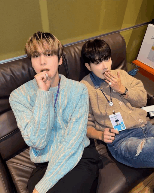 two young men are sitting on a couch and one has a name tag that says ' hyunjae '