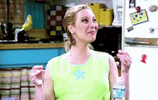 a pixelated image of a woman holding a bottle of water in front of a refrigerator