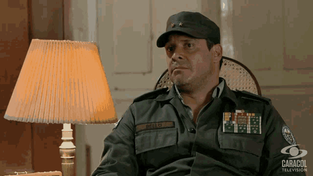 a man in a military uniform is sitting in a chair next to a lamp and the word caracol is on the bottom
