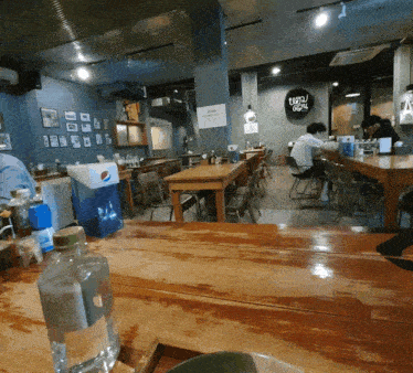 a bottle of pepsi sits on a table in a dining room
