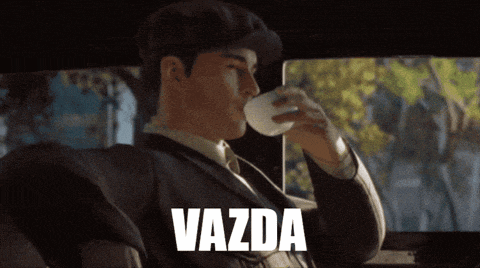 a man in a suit drinking a cup of coffee with the word vazda written below him