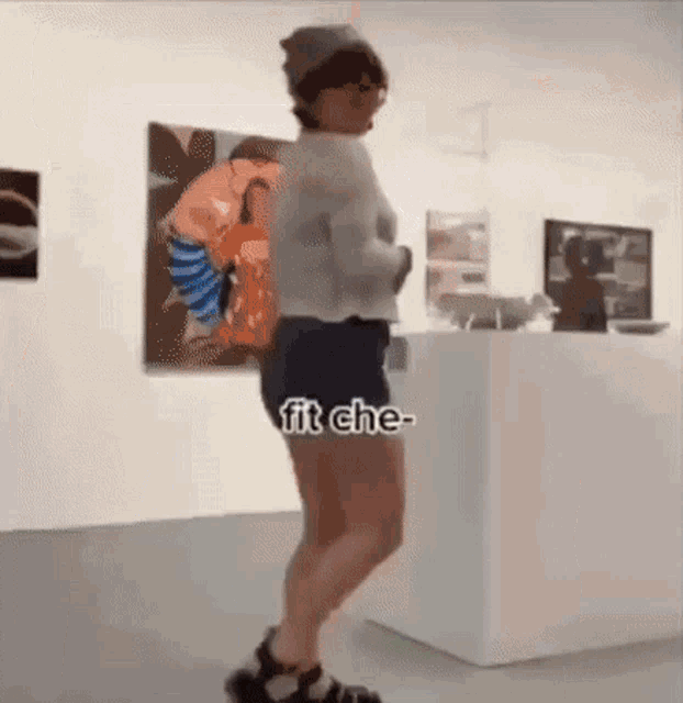 a woman is standing in front of a painting in a museum with the caption fit che .