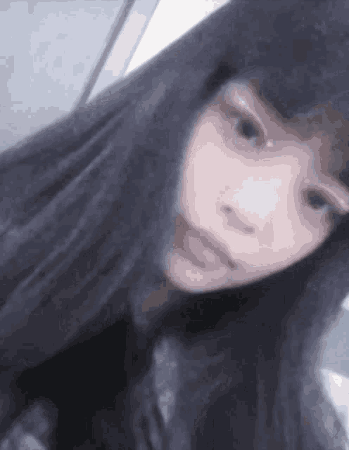 a close up of a woman 's face with long black hair